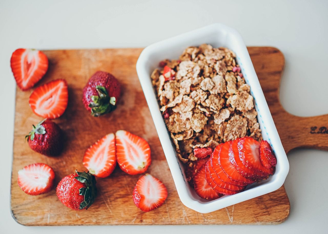Crafting Captivating Headlines: Your awesome post title goes here Delicious granola served with fresh strawberries on a wooden chopping board.