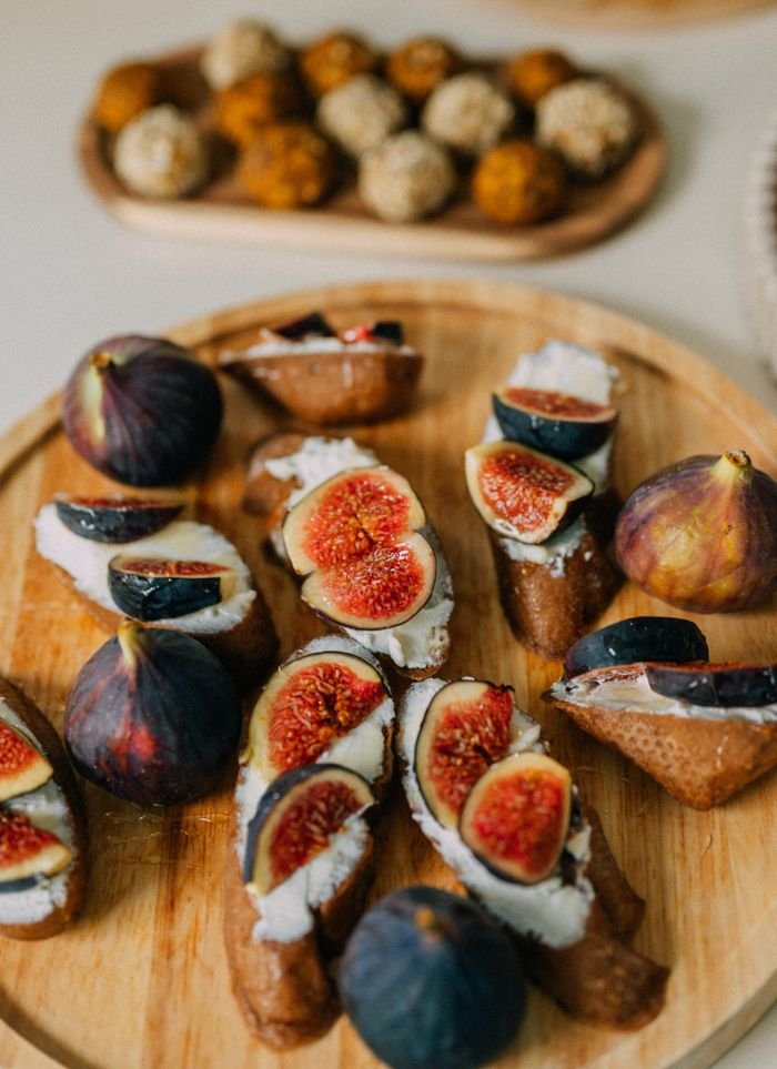 Delicious crostini topped with figs and cheese, served on a rustic wooden platter for a gourmet appetizer.