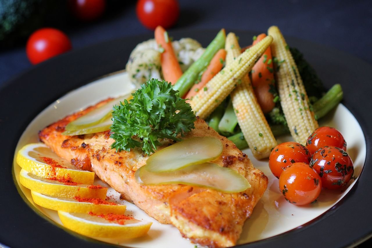 The Art of Drawing Readers In: Your attractive post title goes here A beautifully plated salmon dish with fresh vegetables and lemon slices, perfect for a gourmet meal.