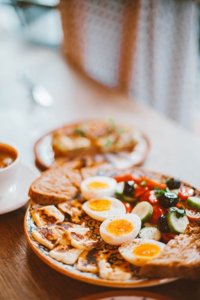 Delicious brunch plate with boiled eggs, fresh vegetables, and toast.